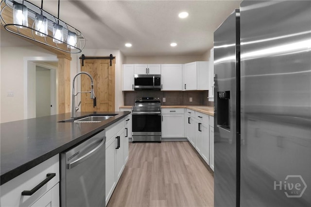114 Paradise Dr, Savannah, GA 31406 - kitchen with appliances with stainless steel finishes, a barn door, white cabinetry, recessed lighting, and light wood-style flooring