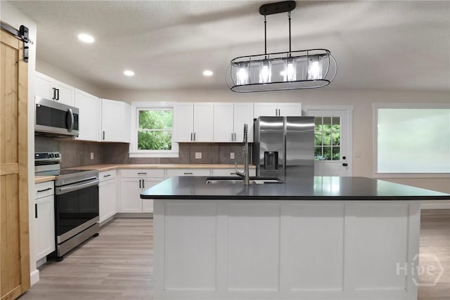 114 Paradise Dr, Savannah, GA 31406 - kitchen featuring appliances with stainless steel finishes, light wood-type flooring, dark countertops, recessed lighting, and white cabinetry