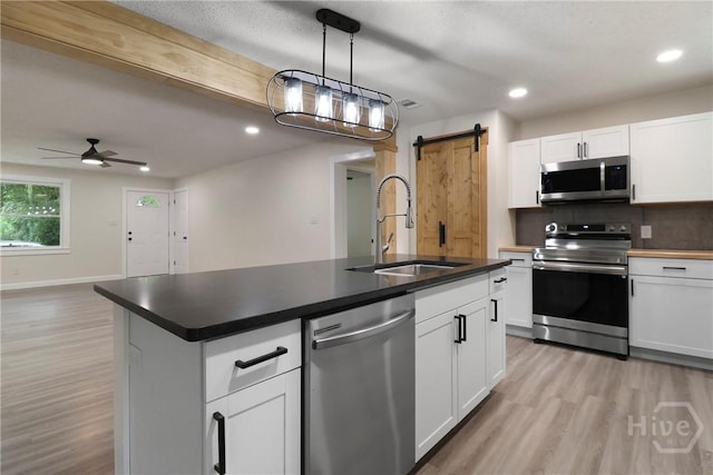 114 Paradise Dr, Savannah, GA 31406 - kitchen featuring stainless steel appliances, a barn door, light wood-style floors, recessed lighting, and a ceiling fan