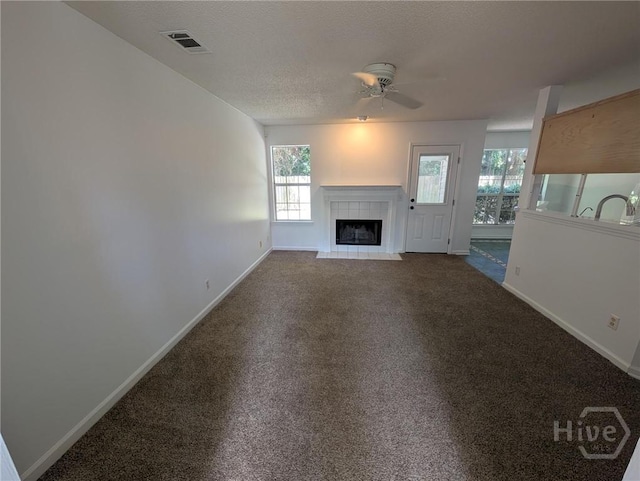 47 Rose Hill Dr, Savannah, GA 31419 - unfurnished living room with healthy amount of natural light, a fireplace, ceiling fan, carpet flooring, and a textured ceiling