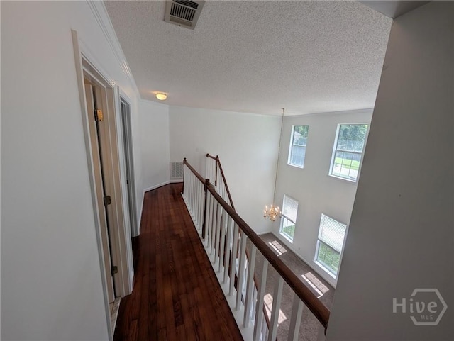 47 Rose Hill Dr, Savannah, GA 31419 - hall featuring an upstairs landing, wood finished floors, a textured ceiling, and a chandelier