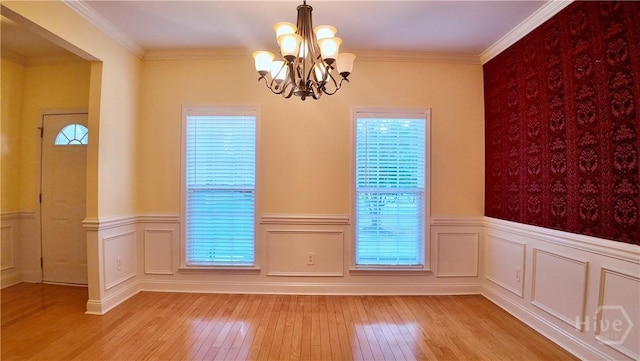 131 Brigham Dr, Richmond Hill, GA 31324 - empty room with healthy amount of natural light, light wood finished floors, a chandelier, wainscoting, and ornamental molding