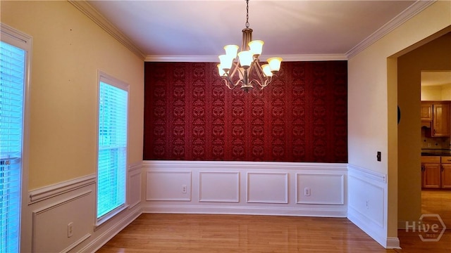 131 Brigham Dr, Richmond Hill, GA 31324 - unfurnished dining area featuring a chandelier, wallpapered walls, wood finished floors, a wainscoted wall, and plenty of natural light