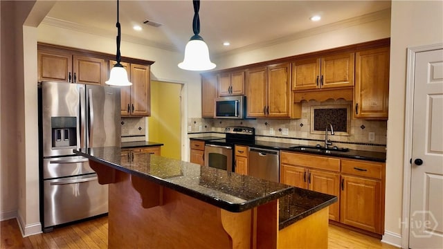 131 Brigham Dr, Richmond Hill, GA 31324 - kitchen with appliances with stainless steel finishes, a center island, light wood-style floors, decorative light fixtures, and crown molding