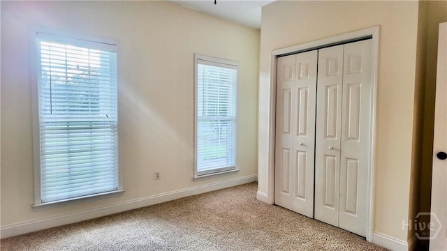 131 Brigham Dr, Richmond Hill, GA 31324 - unfurnished bedroom with light colored carpet, a closet, and multiple windows