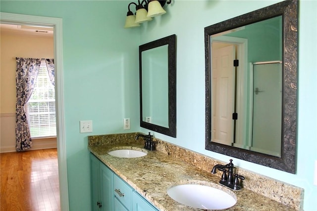 131 Brigham Dr, Richmond Hill, GA 31324 - full bath with double vanity, wood finished floors, and a shower with shower door