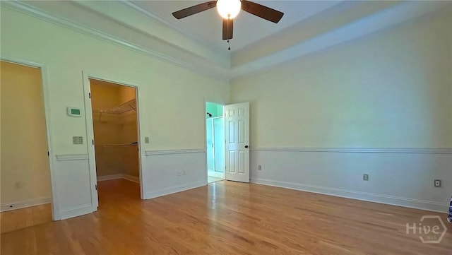 131 Brigham Dr, Richmond Hill, GA 31324 - unfurnished bedroom featuring wood finished floors, a spacious closet, a closet, ornamental molding, and a ceiling fan