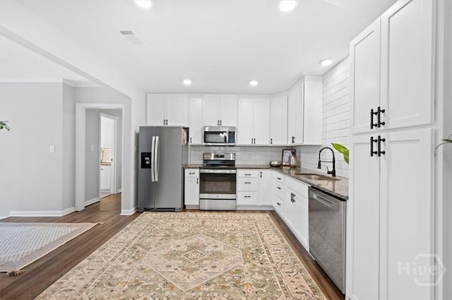 4611 Cumberland Dr, Savannah, GA 31405 - kitchen featuring stainless steel appliances, dark wood-style floors, decorative backsplash, white cabinets, and recessed lighting