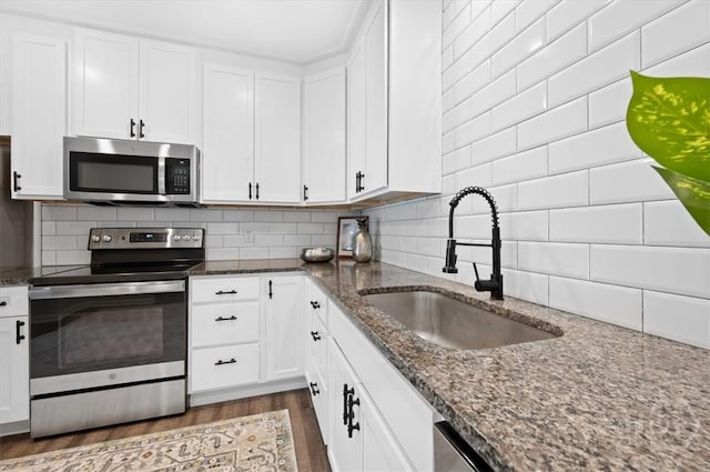 4611 Cumberland Dr, Savannah, GA 31405 - kitchen with appliances with stainless steel finishes, dark wood-style floors, and white cabinets