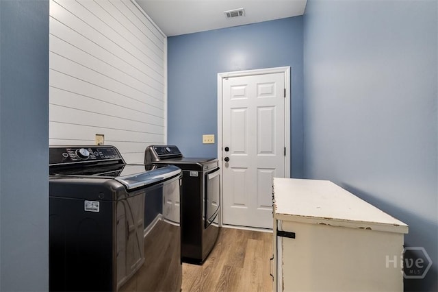 172 Green Paddock Cir, Guyton, GA 31312 - laundry area featuring separate washer and dryer, light wood-style flooring, and wood walls