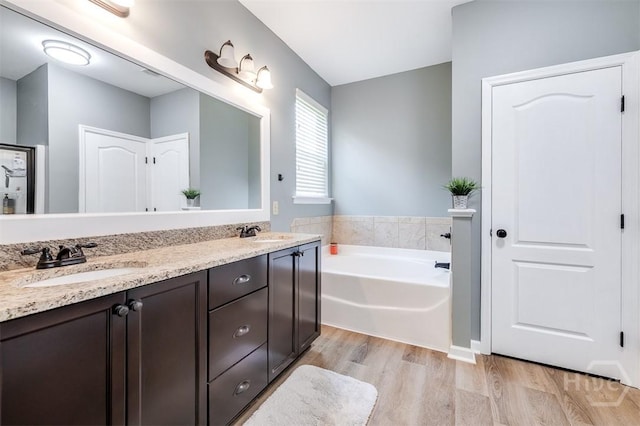 172 Green Paddock Cir, Guyton, GA 31312 - bathroom with wood finished floors, double vanity, and a bath