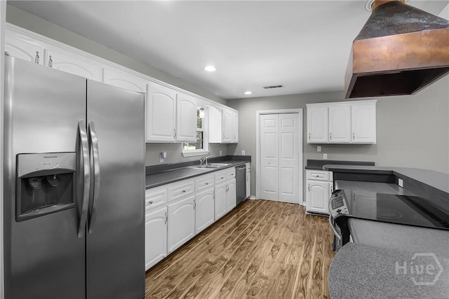 324 Elm St, Eden, GA 31307 - kitchen with appliances with stainless steel finishes, extractor fan, wood finished floors, dark countertops, and recessed lighting