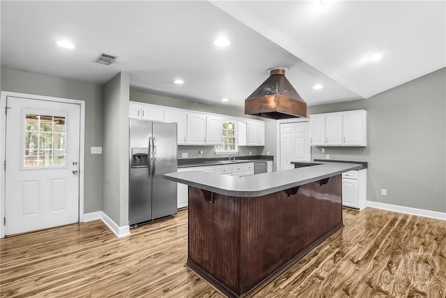 324 Elm St, Eden, GA 31307 - kitchen with stainless steel appliances, white cabinets, light wood-style floors, a kitchen island, and island range hood