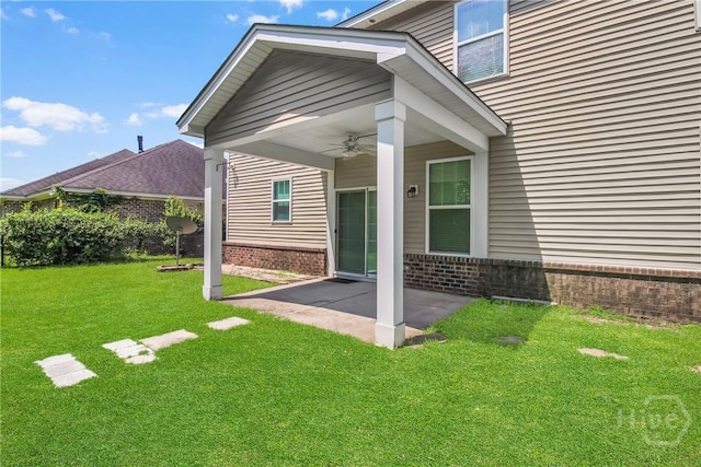 129 Winslow Cir, Savannah, GA 31407 - view of exterior entry with a ceiling fan, brick siding, a patio, and a lawn