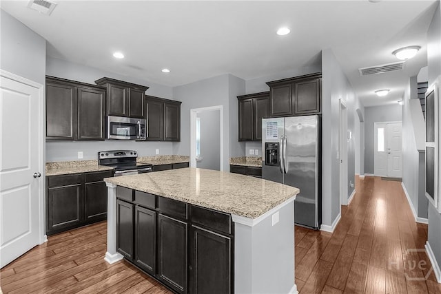 129 Winslow Cir, Savannah, GA 31407 - kitchen with appliances with stainless steel finishes, a kitchen island, dark wood-style flooring, light stone counters, and recessed lighting