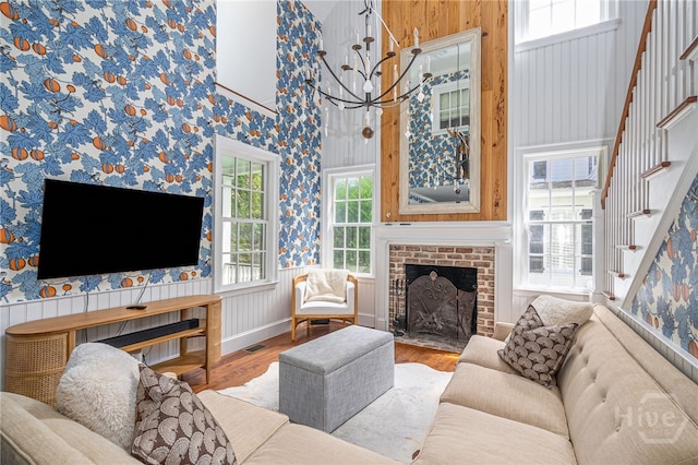 46 Cherry Laurel Ln, Richmond Hill, GA 31324 - living area with wood finished floors, stairs, a chandelier, a fireplace, and wallpapered walls