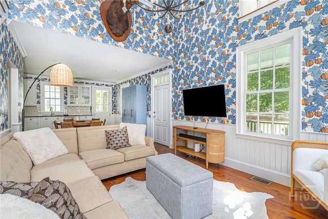46 Cherry Laurel Ln, Richmond Hill, GA 31324 - living area featuring wallpapered walls, wood finished floors, and ornamental molding
