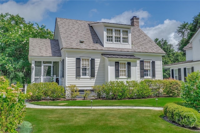46 Cherry Laurel Ln, Richmond Hill, GA 31324 - view of front facade featuring a chimney, a sunroom, and a front lawn