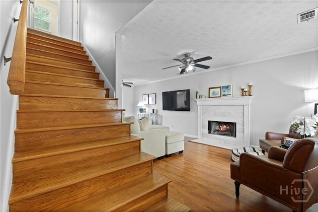 139 Marsh Edge Ln, Savannah, GA 31419 - living area with a textured ceiling, stairs, a ceiling fan, a tile fireplace, and wood finished floors