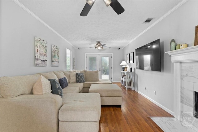 139 Marsh Edge Ln, Savannah, GA 31419 - living room featuring a ceiling fan, a tile fireplace, ornamental molding, wood finished floors, and a textured ceiling