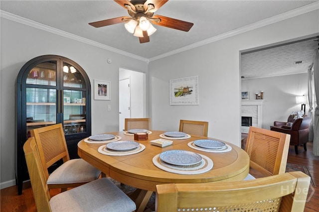 139 Marsh Edge Ln, Savannah, GA 31419 - dining area featuring wood finished floors, ceiling fan, a fireplace, and crown molding