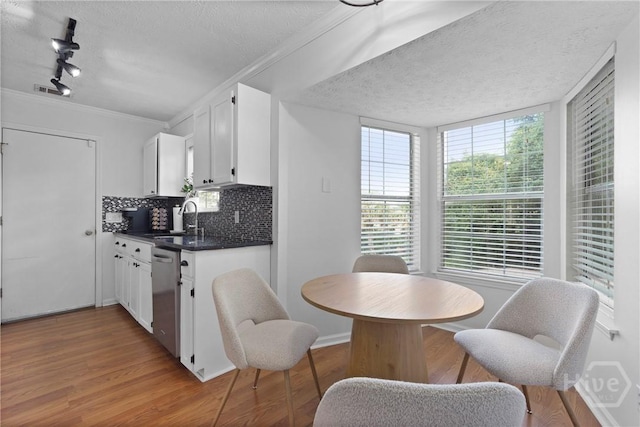 139 Marsh Edge Ln, Savannah, GA 31419 - kitchen with a textured ceiling, dishwasher, dark countertops, wood finished floors, and decorative backsplash