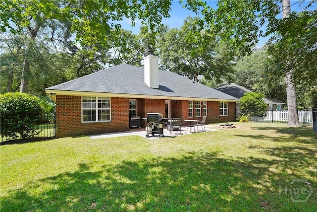 27 Heron View Ct, Richmond Hill, GA 31324 - rear view of house featuring a fenced backyard, an outdoor fire pit, a chimney, a patio, and brick siding
