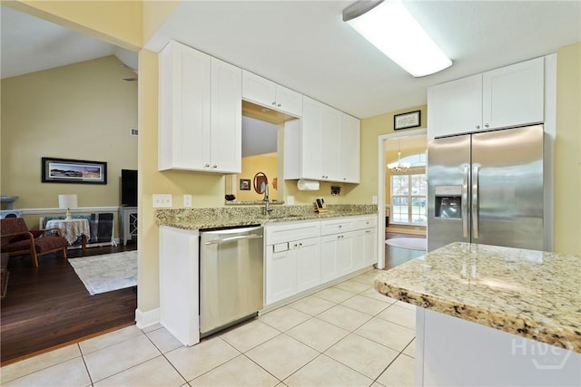 27 Heron View Ct, Richmond Hill, GA 31324 - kitchen featuring stainless steel appliances, light tile patterned floors, white cabinetry, and light stone counters