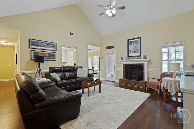 27 Heron View Ct, Richmond Hill, GA 31324 - living area featuring high vaulted ceiling, dark wood finished floors, ceiling fan, a brick fireplace, and healthy amount of natural light