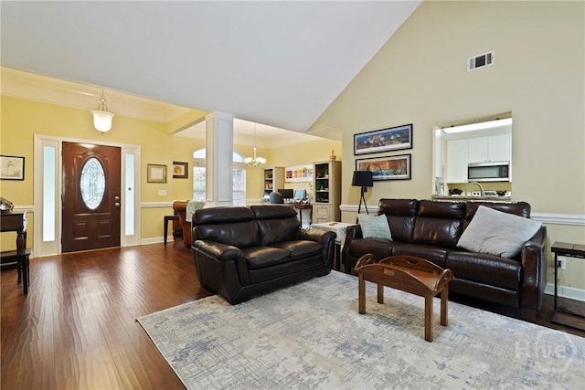 27 Heron View Ct, Richmond Hill, GA 31324 - living room featuring high vaulted ceiling, wood finished floors, a chandelier, ornate columns, and ornamental molding