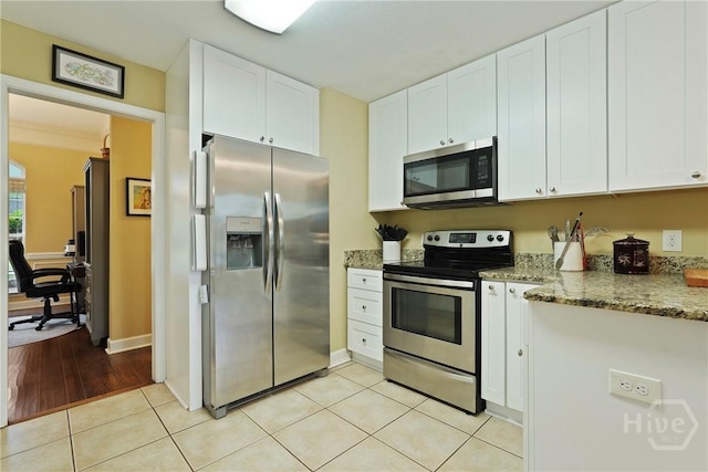 27 Heron View Ct, Richmond Hill, GA 31324 - kitchen with stainless steel appliances, white cabinets, light stone counters, and light tile patterned flooring