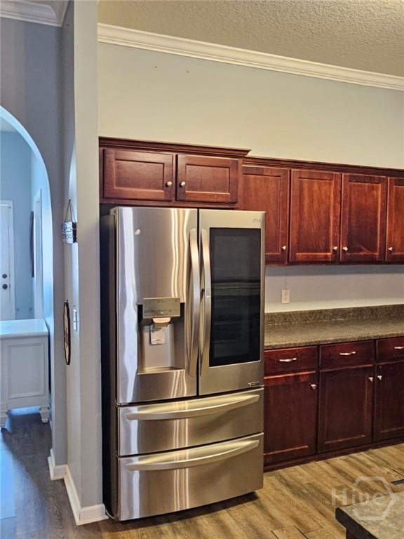 401 Barry Mccaffrey Blvd Unit E2, Hinesville, GA 31313 - kitchen featuring stainless steel fridge with ice dispenser, light wood-type flooring, arched walkways, ornamental molding, and dark countertops