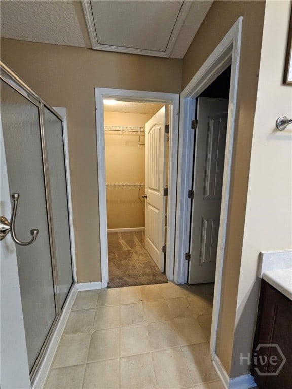 401 Barry Mccaffrey Blvd Unit E2, Hinesville, GA 31313 - full bath featuring a shower stall, a walk in closet, vanity, and tile patterned floors