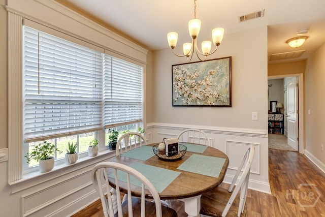 160 Wild Honey Ct, Richmond Hill, GA 31324 - dining room with a chandelier, wood finished floors, and a wainscoted wall