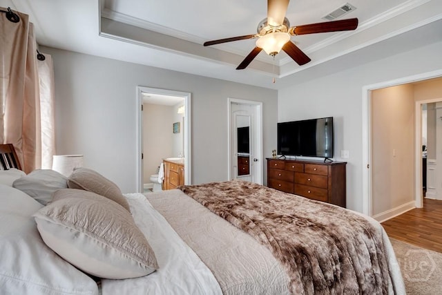 160 Wild Honey Ct, Richmond Hill, GA 31324 - bedroom featuring a tray ceiling, ornamental molding, wood finished floors, a ceiling fan, and ensuite bathroom