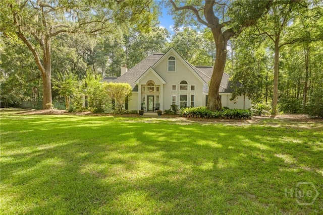 139 Mingarry Dr, Richmond Hill, GA 31324 - view of front facade with french doors, a chimney, a front lawn, stucco siding, and a shingled roof
