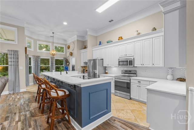 139 Mingarry Dr, Richmond Hill, GA 31324 - kitchen with stainless steel appliances, white cabinets, light countertops, crown molding, and a high ceiling