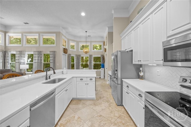 139 Mingarry Dr, Richmond Hill, GA 31324 - kitchen featuring stainless steel appliances, crown molding, light countertops, tasteful backsplash, and plenty of natural light