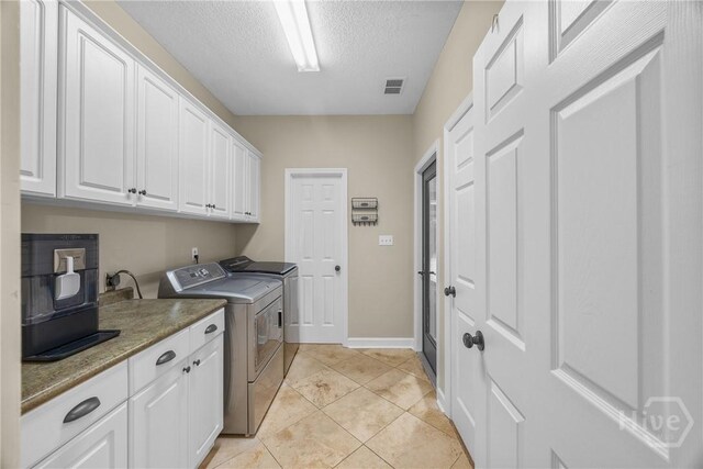 139 Mingarry Dr, Richmond Hill, GA 31324 - laundry area with separate washer and dryer, cabinet space, a textured ceiling, and light tile patterned flooring