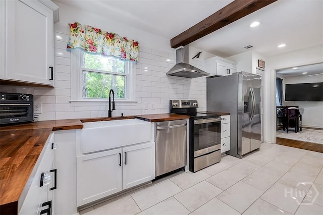 2338 Lorraine Dr, Savannah, GA 31404 - kitchen featuring butcher block countertops, extractor fan, stainless steel appliances, decorative backsplash, and beam ceiling
