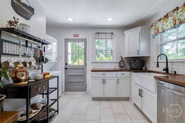 2338 Lorraine Dr, Savannah, GA 31404 - kitchen with dishwasher, wood counters, light tile patterned flooring, white cabinets, and backsplash