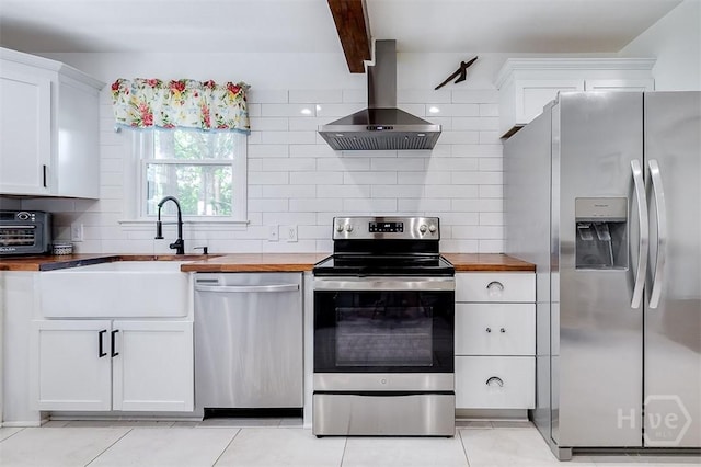 2338 Lorraine Dr, Savannah, GA 31404 - kitchen featuring appliances with stainless steel finishes, wall chimney range hood, wood counters, backsplash, and white cabinets