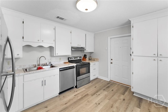 129 Vandiver Rd, Walthourville, GA 31301 - kitchen with appliances with stainless steel finishes, under cabinet range hood, light wood-style flooring, light countertops, and white cabinets