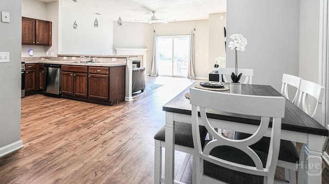 1125 Canyon Oak Loop, Richmond Hill, GA 31324 - kitchen with dishwasher, ceiling fan, light wood-style flooring, dark brown cabinetry, and a textured ceiling