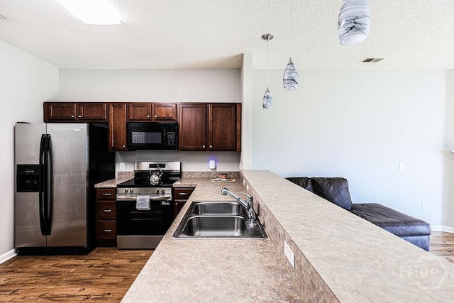 1125 Canyon Oak Loop, Richmond Hill, GA 31324 - kitchen with stainless steel appliances, dark wood-style flooring, dark brown cabinets, a textured ceiling, and hanging light fixtures