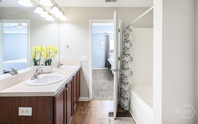 1125 Canyon Oak Loop, Richmond Hill, GA 31324 - ensuite bathroom featuring wood finished floors, double vanity, shower / bath combo, and ceiling fan