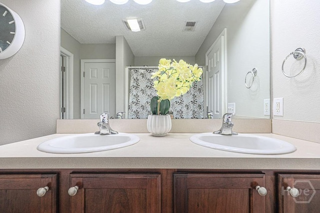 1125 Canyon Oak Loop, Richmond Hill, GA 31324 - bathroom with double vanity, a textured ceiling, and a textured wall