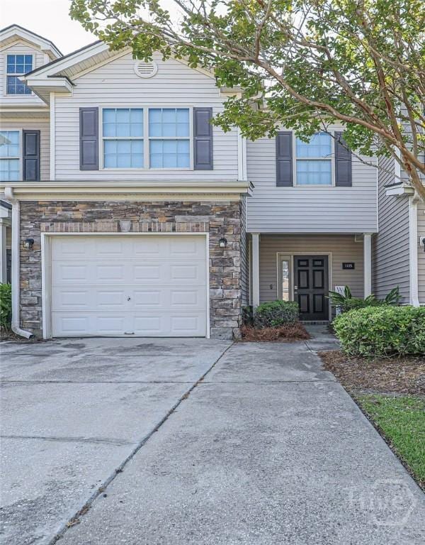1125 Canyon Oak Loop, Richmond Hill, GA 31324 - view of front facade featuring stone siding, a garage, and driveway