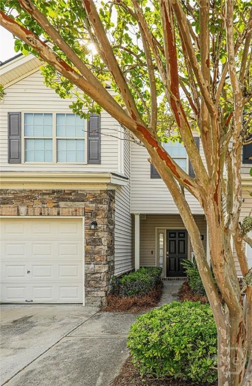 1125 Canyon Oak Loop, Richmond Hill, GA 31324 - view of front of property with a garage, stone siding, and driveway
