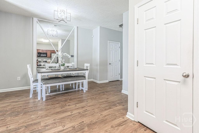 1125 Canyon Oak Loop, Richmond Hill, GA 31324 - dining area featuring wood finished floors, a textured ceiling, and a chandelier